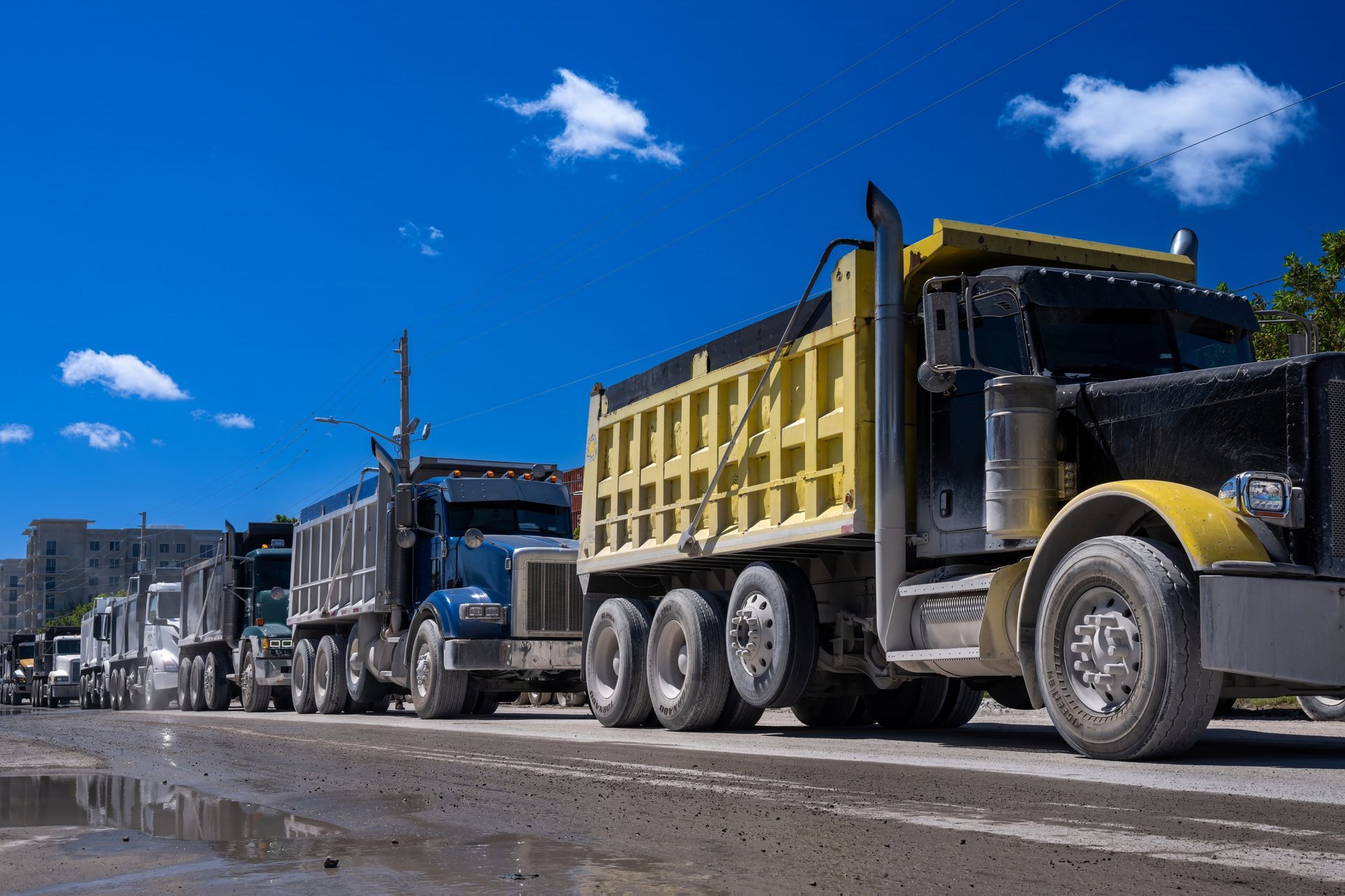 Row of dump trucks on the street waiting to load